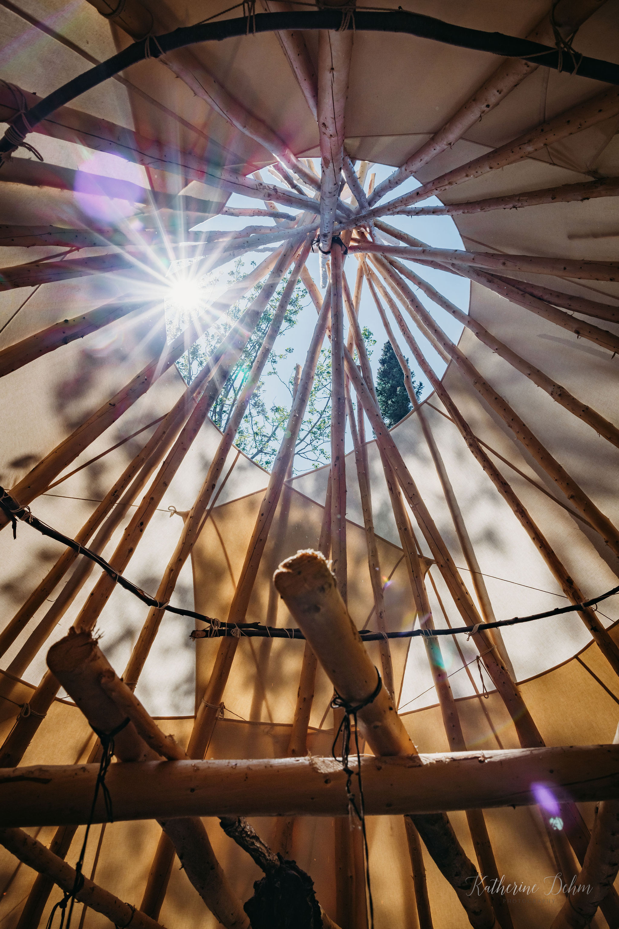 Sunlight through the poles of a traditional teepee frame